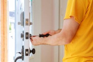 Worker installing or repairing new lock handyman repair the door lock